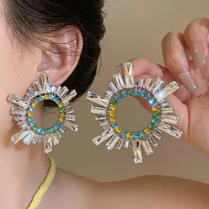 Dettaglio ravvicinato di orecchini vintage a raggiera con cristalli colorati e argento.