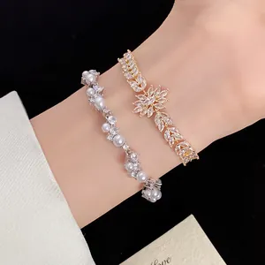 Macro view of zircon wheat floral and pearl wave bracelets on a wrist