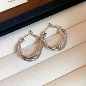 Close-up detail of silver-tone double-layered twisted hoop earrings in a jewelry box