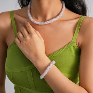 Detail view of iridescent crystal beaded necklace and matching bracelet worn by model