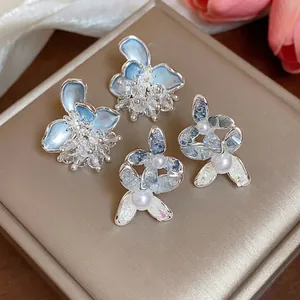 Elegant silver flower and pearl stud earrings set with sparkling crystal details