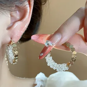 Detailed view of light luxury gold-plated hoop earrings with sparkling crushed crystals