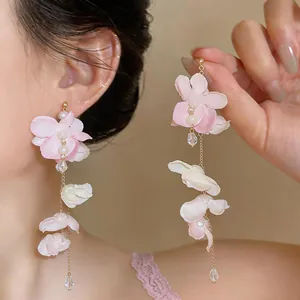 Close-up detail of elegant long pink floral tassel earrings with pearl accents