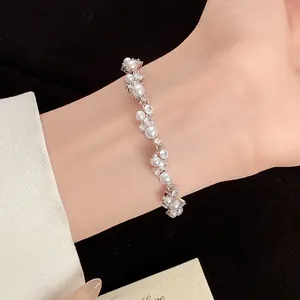 Detailed view of an elegant irregular silver bracelet featuring pearls and cubic zirconia stones
