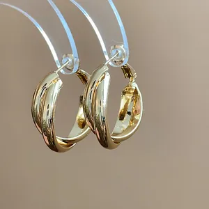 Detailed view of 18K gold plated twisted hoop earrings with elegant glossy finish