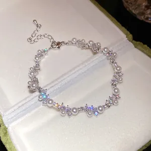 Detailed macro view of elegant zircon and pearl wheat ear bracelet in a premium gift box