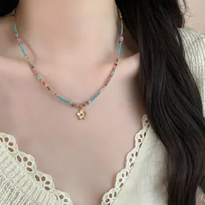 Vintage ethnic style beaded stone necklace featuring a dainty golden flower pendant
