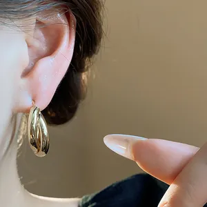 Detailed close-up showing elegant 18K gold-plated minimalist double-layer hoop earrings