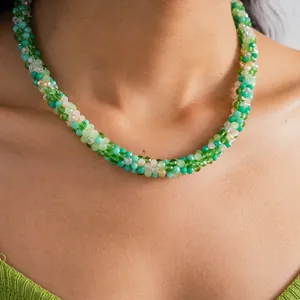 Close-up of elegant green and white crystal beaded braided necklace on model's neck