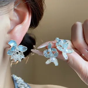 Close-up detail of elegant glass flower earrings with pearls and crystal accents.