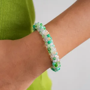 Close-up of a vibrant green crystal beaded magnetic bracelet worn on a wrist