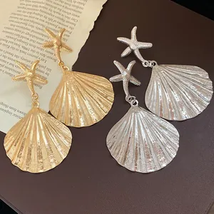 Detailed view of gold and silver pleated shell earrings with elegant starfish studs.