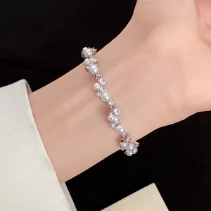 Elegant detail view of a zircon and pearl wheat ear flower bracelet on a model's wrist