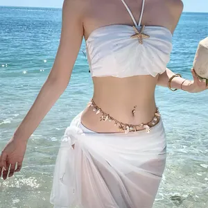 Detailed view of a bohemian style gold waist chain with sea shell and pearl charms
