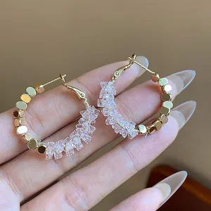 Detailed close-up view of 14K gold plated hoop earrings with clear faceted crystals