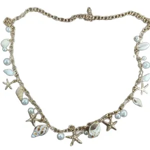 Bohemian gold chain waist belt with shells, starfish, and pearls for beach wear.
