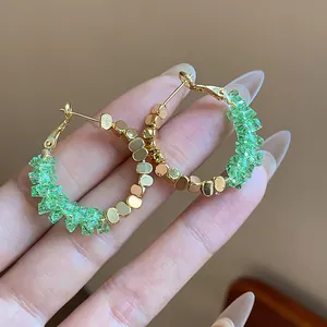 Detail view of 14K gold plated hoop earrings with crushed green crystals and beads