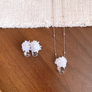 Ensemble collier et boucles d'oreilles fleurs blanches avec gouttes en cristal