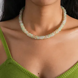Detail shot of a delicate crystal beaded choker necklace with green and peach tones