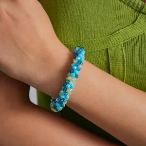 Close-up of a blue and green crystal beaded magnetic bracelet on a model's wrist.