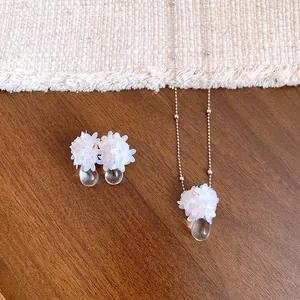 Vue détaillée de l'ensemble collier et boucles d'oreilles fleur à paillettes avec pendentifs