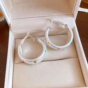 Elegant silver brushed hoop earrings with colorful dopamine polka dots in a beige gift box