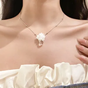 Détail d'un collier de fleurs blanches avec un pendentif en goutte d'eau élégant
