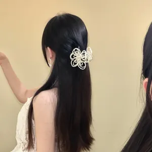 Elegant white pearl flower hair claw clip detail view on a model with long hair