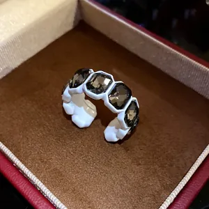 Dettaglio macro di un anello aperto regolabile in stile vintage con strass scuri esagonali