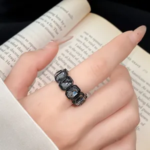 Primo piano dettagliato di un anello vintage con strass esagonali neri portato al dito
