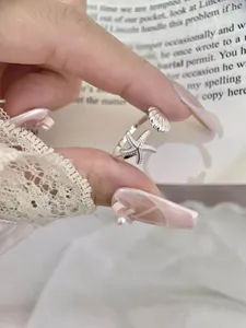 Exquisite detail shot of silver starfish and shell open ring with adjustable band