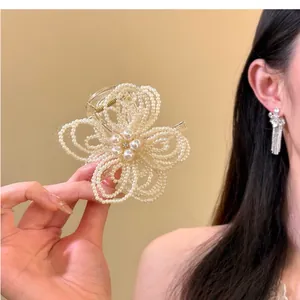 Detailed view of elegant pearl flower hair claw clip for sophisticated bun hairstyles