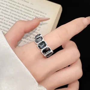Dettaglio ravvicinato di un anello in stile retro dark con gemme nere sul dito di un modello