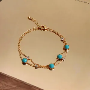 Detail of a vintage gold bracelet featuring round turquoise stones and clear crystals.