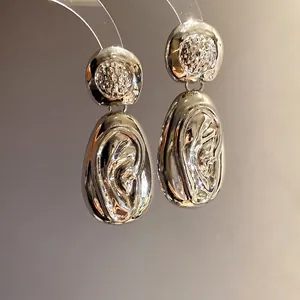 Minimalist silver drop earrings with a unique wrinkled molten texture and round studs