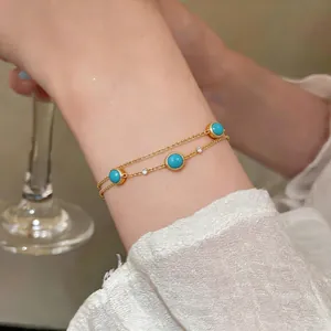 Exquisite double-layer gold chain bracelet with vibrant turquoise stones on a model's wrist