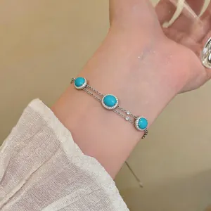Close-up of elegant turquoise bracelet with halo crystals on silver double chain