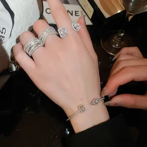 Primo piano di un set di anelli e bracciali in zircone scintillante sulla mano.