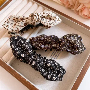 Détail de trois pinces à cheveux en tissu floral dans un plateau de boîte à bijoux