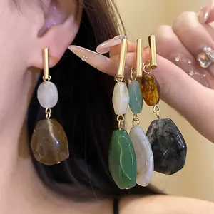 Close-up detail of geometric resin earrings showing multiple colors and textures