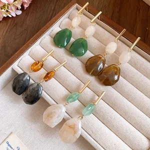 Close-up of vintage-style resin geometric drop earrings with gold-toned bars in a tray