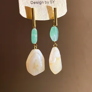 Close-up of elegant resin geometric drop earrings with green and white marble texture