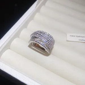 Dettaglio macro di un ampio anello a croce argento tempestato di micro zirconi scintillanti