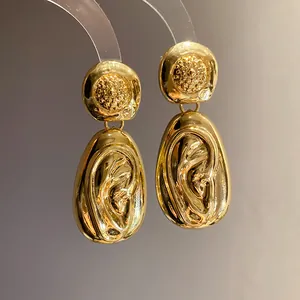 Detailed view of elegant gold water drop earrings with unique ear-shaped textured drops