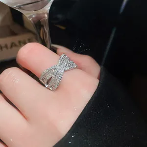 Primo piano dettagliato di un anello a incrocio in argento con zirconi a baguette