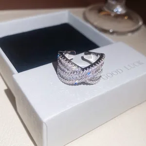 Primo piano dettagliato di un anello incrociato in zircone argentato in una scatola bianca