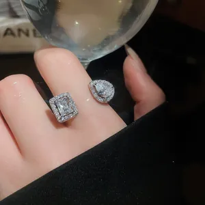 Primo piano di un anello aperto argentato con design in zircone quadrato e a goccia