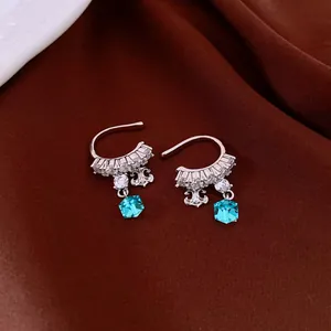 Close-up of elegant silver-toned floral zircon ear cuffs with blue hexagonal gemstone drops