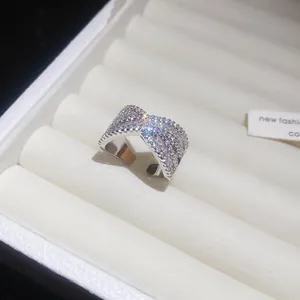 Dettaglio di un elegante anello incrociato color argento con zirconi scintillanti