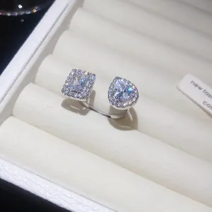 Vista dettagliata di un anello aperto in argento con zirconi quadrati e a goccia